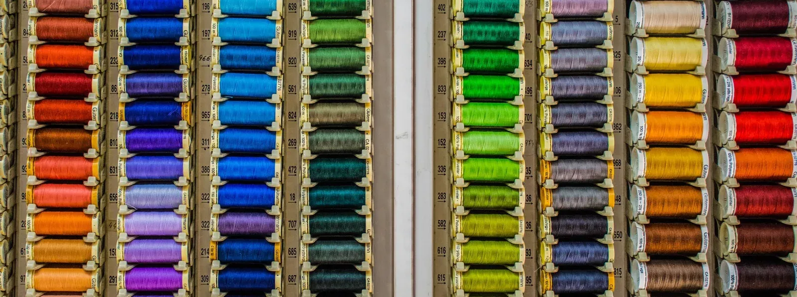 Bobine de fire colorate în rânduri — producție confecții textile la comandă